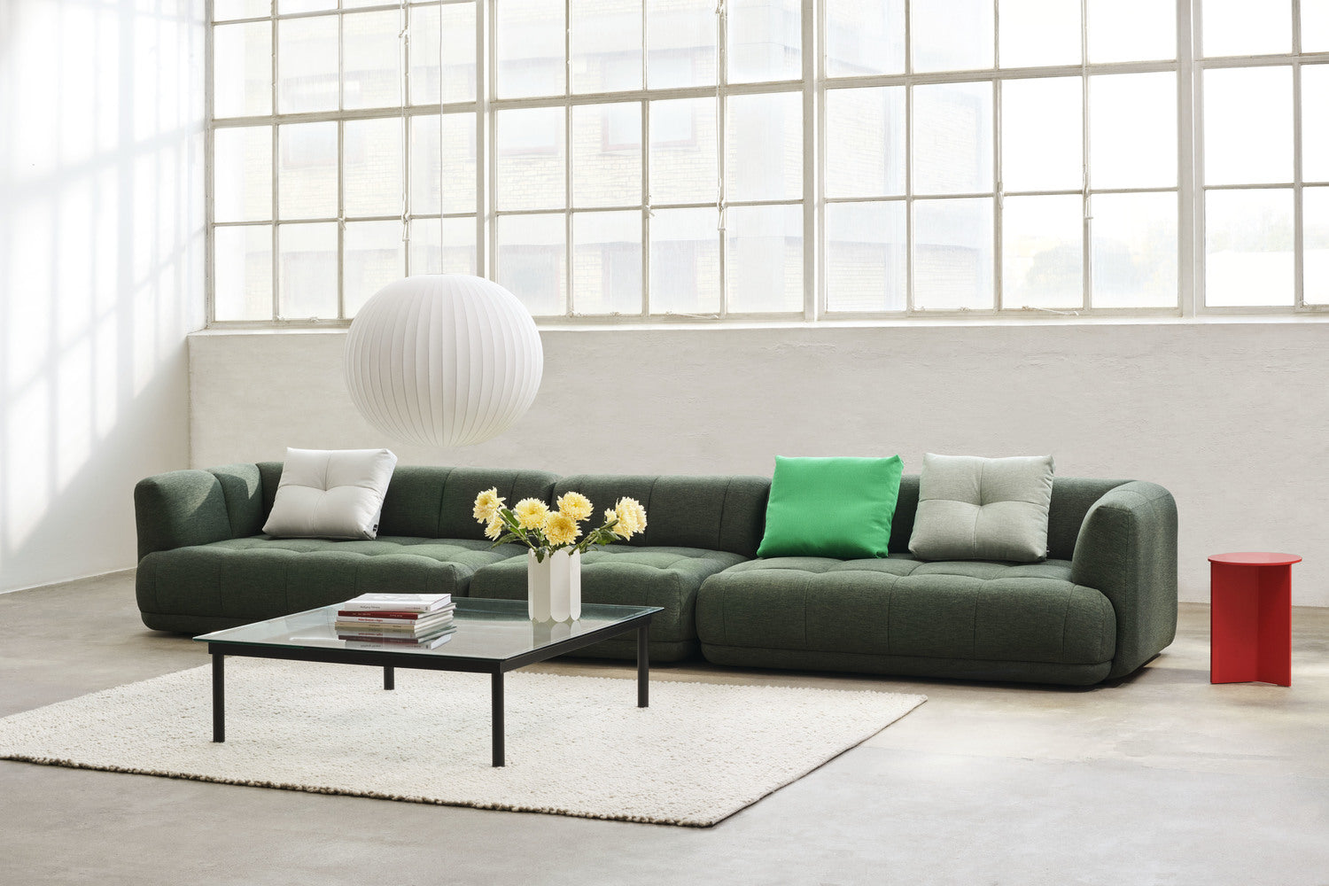 Green HAY modular sofa arranged in a bright contemporary living room.