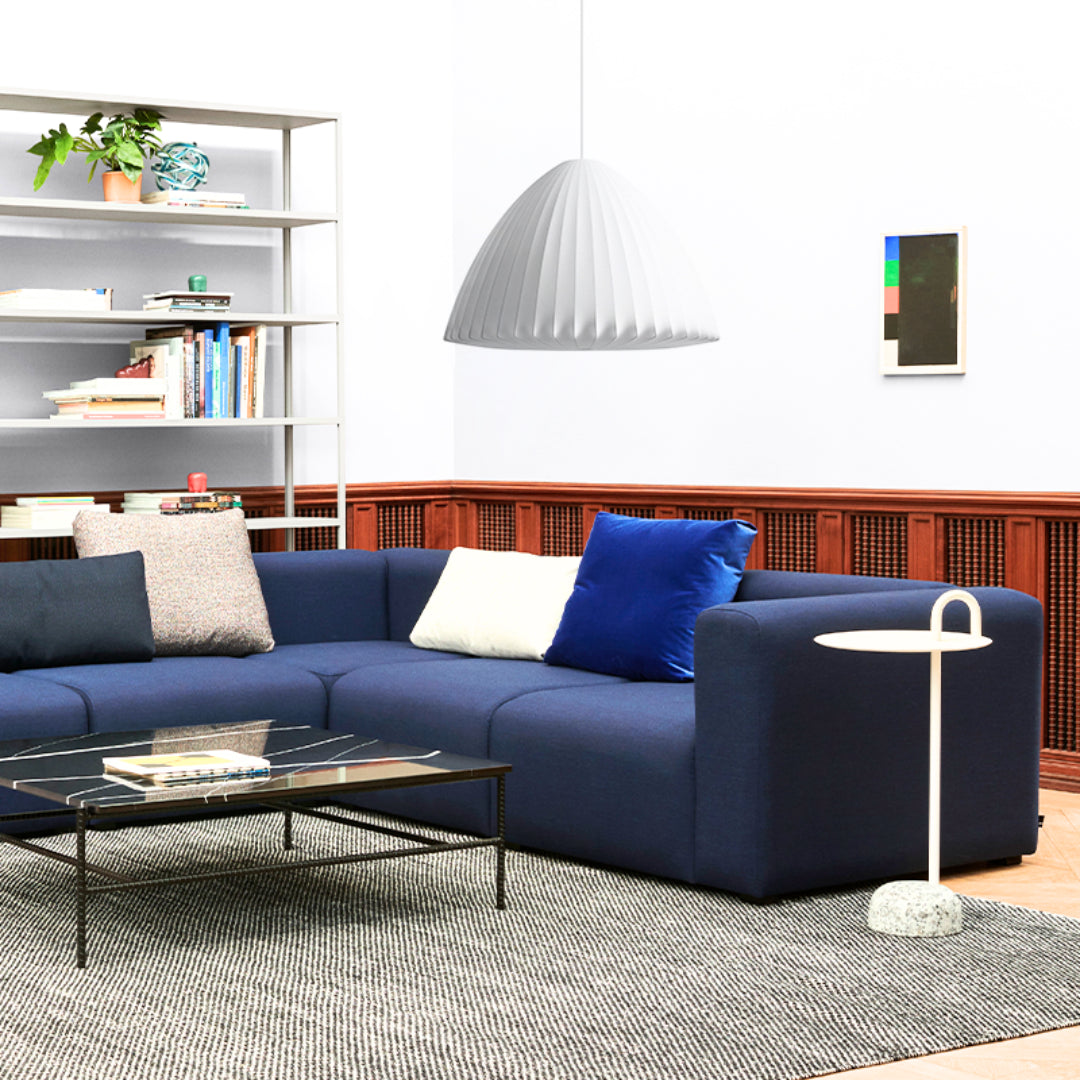 HAY Nelson Bell Bubble Pendant XL in off-white above a blue sectional sofa in a living room.