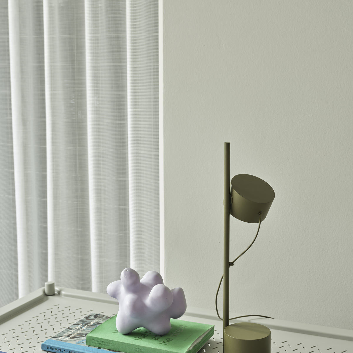 Muuto Post Table Lamp in brown green beside a window with a Flow coffee table