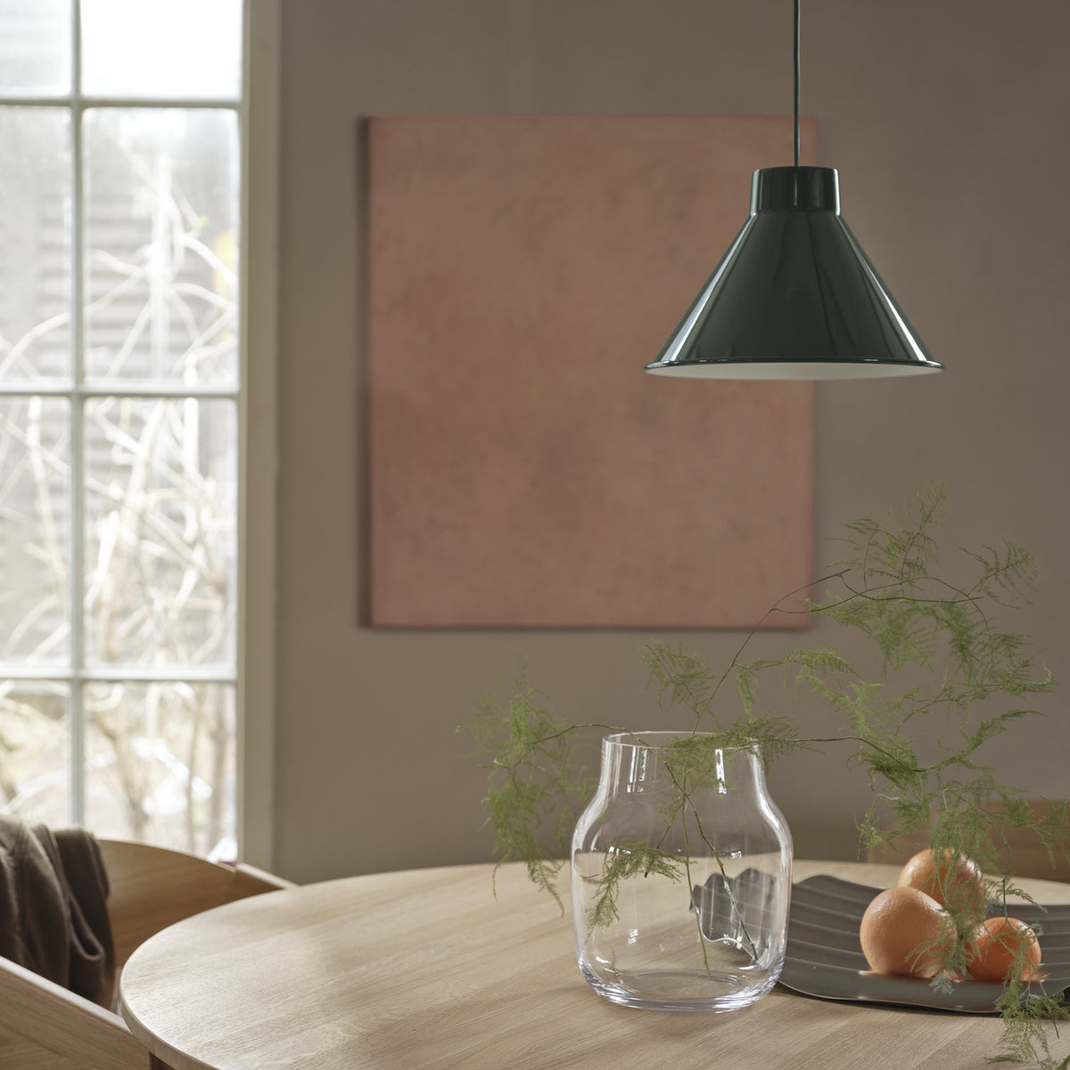 Muuto Top family context: a single 28 cm dark green pendant above a dining table