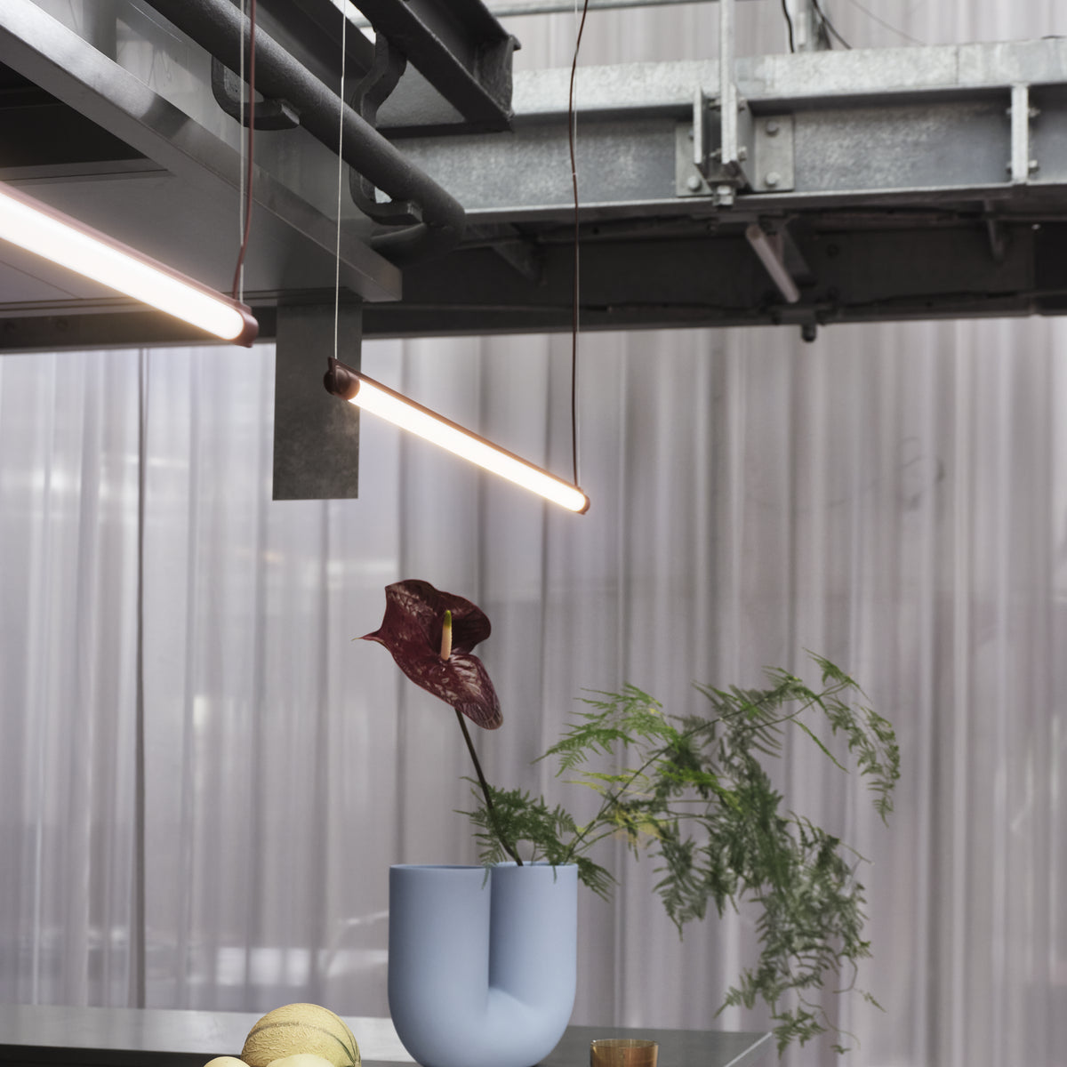 Muuto Fine Suspension Lamp 90 cm in deep red illuminating a console with Muuto accessories; installation context