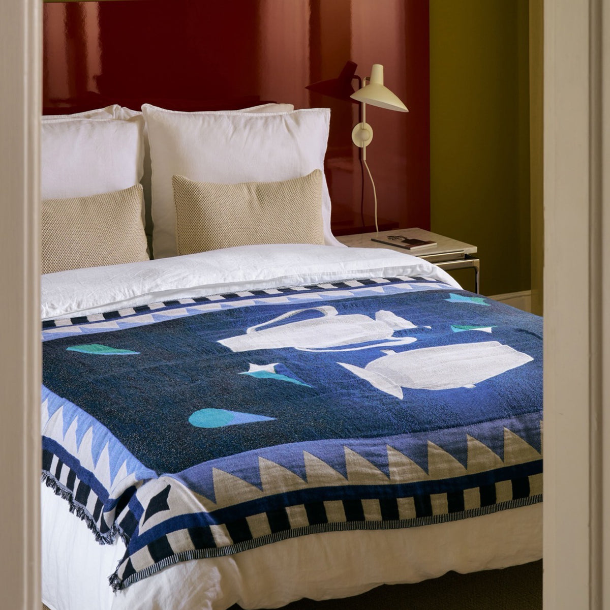 Blue patterned Momento throw across a bed