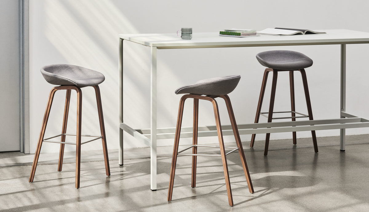 HAY AAS 33 High upholstered stools with walnut legs beside a New Order high table