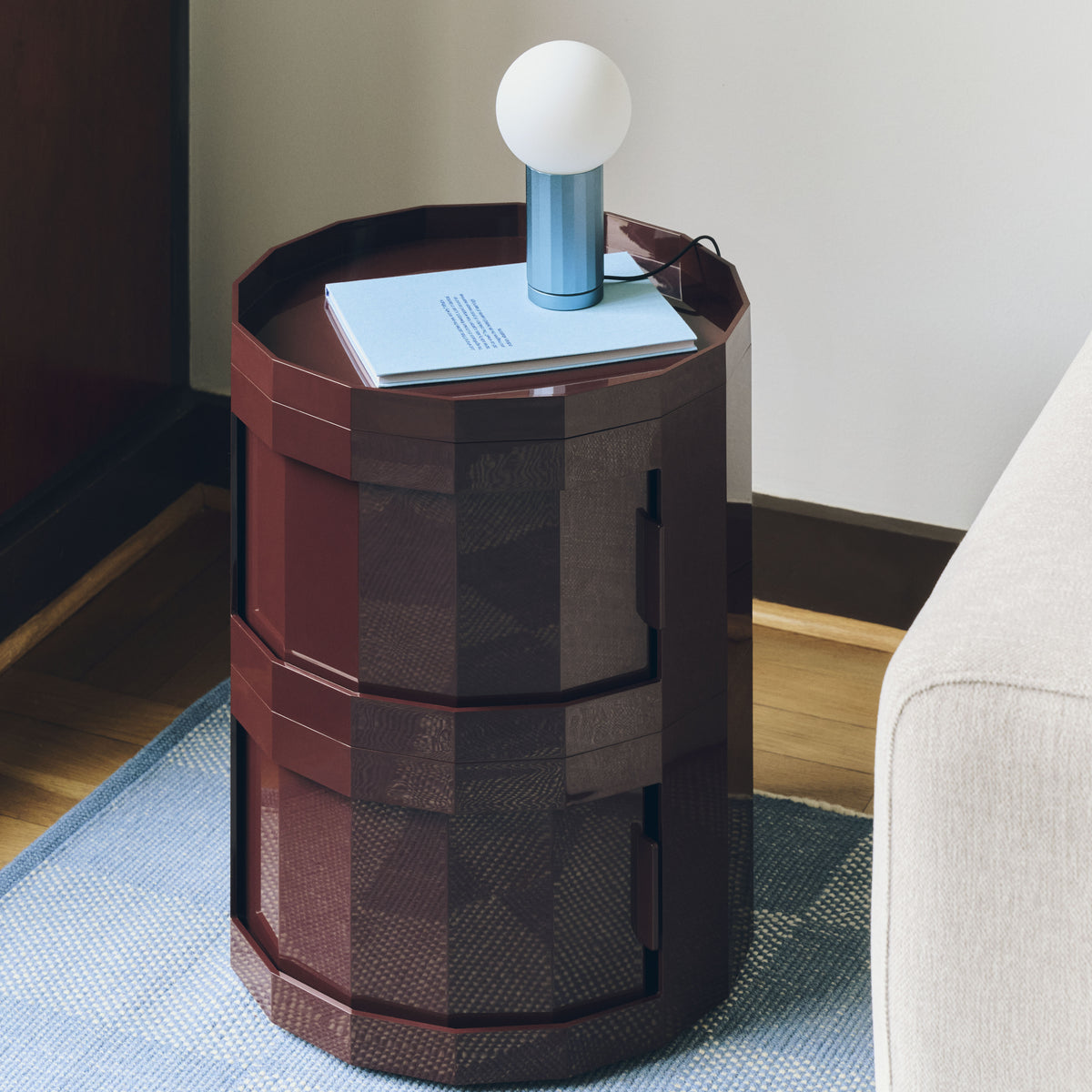 HAY Turn On Table Lamp in blue anodised aluminium on a burgundy Facet Cabinet